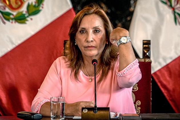 Tổng thống Peru Dina Boluarte giơ tay đeo đồng hồ, cho hay đó là chiếc Jacques du Manoir mua ở Thụy Sĩ, không phải Rolex, trong cuộc họp báo tại Lima ngày 5/4. Ảnh: AFP