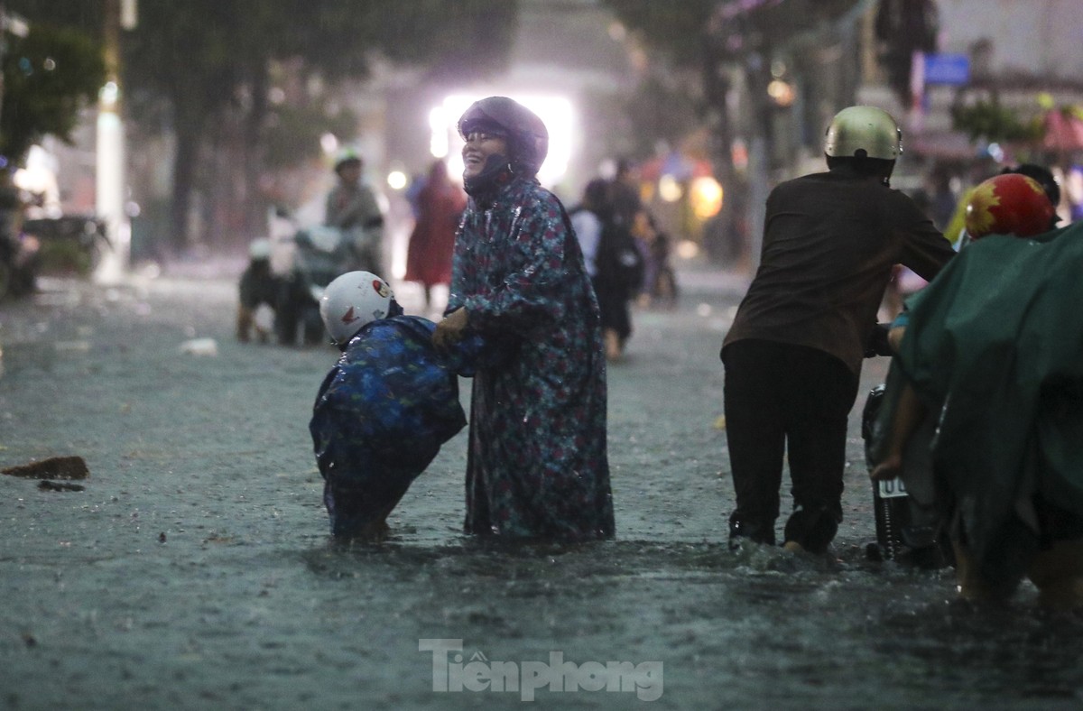 Người dân chật vật vượt biển nước về nhà sau mưa lớn ở TPHCM ảnh 11