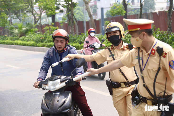 Cảnh sát giao thông ra hiệu dừng xe và kiểm tra nồng độ cồn với tài xế ở Hà Nội - Ảnh: DANH TRỌNG