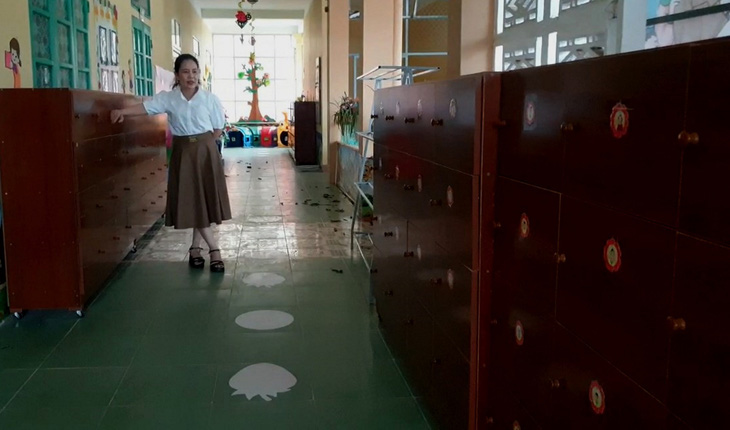 Bà Đinh Thị Bùi Chung, hiệu trưởng Trường mầm non số 1 Quy Đạt, bên những chiếc tủ được đóng từ tiền xã hội hóa của phụ huynh - Ảnh: QUỐC NAM