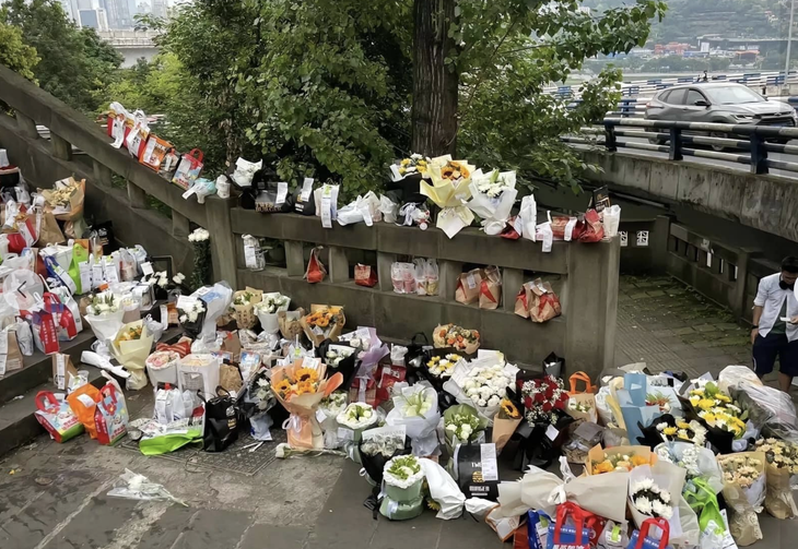 Những bó hoa được người dân Trung Quốc đặt trên cây cầu nơi Mèo Béo tự tử bày tỏ lòng tiếc thương - Ảnh: Weibo