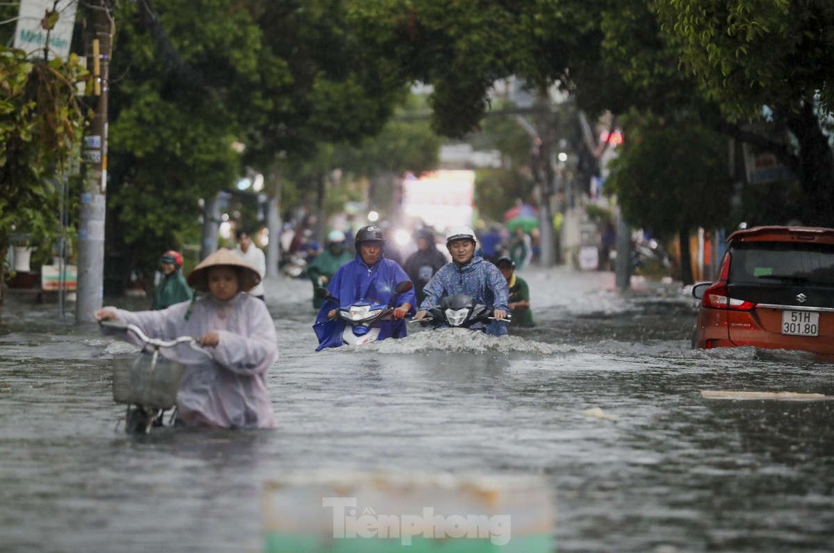 Người dân chật vật vượt biển nước về nhà sau mưa lớn ở TPHCM ảnh 10