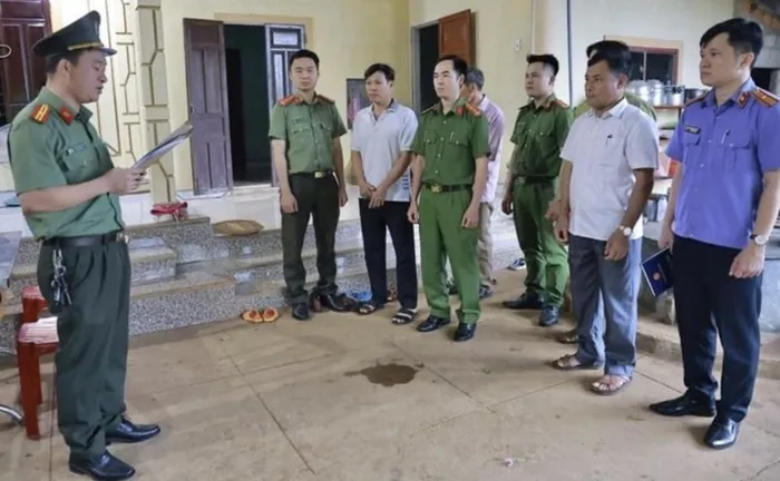 Cơ quan An ninh điều tra Công an tỉnh Quảng Trị đọc lệnh bắt tạm giam đối với Hồ Văn Đức (áo pull, thứ 2, trái sang). Ảnh: CAQT