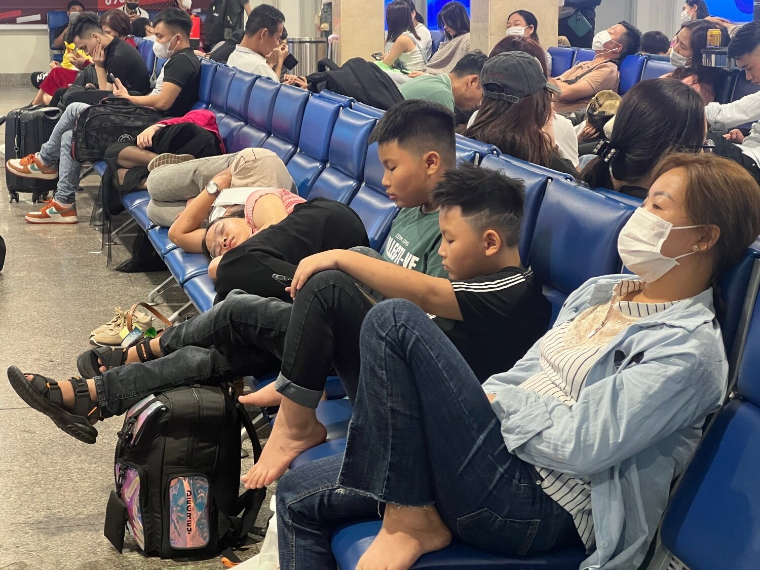 Khách nằm, ngồi la liệt ở sân bay Tân Sơn Nhất ngày 27 Tết - 7