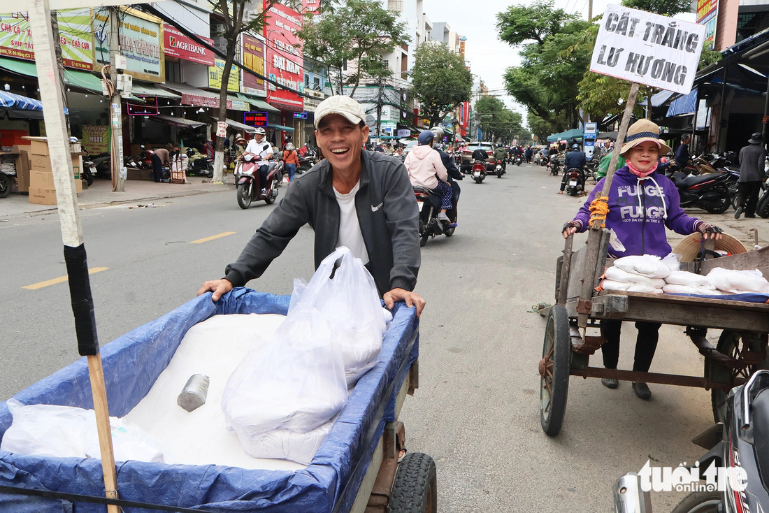 Người dân kéo xe bò chở cát trắng bán ở chợ Cồn - Ảnh: LÊ TRUNG