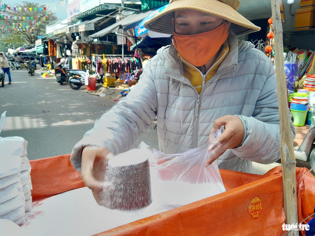 Một phụ nữ bán cát trắng lư hương ở chợ Hòa Khánh - Ảnh: MINH NGUYỆT