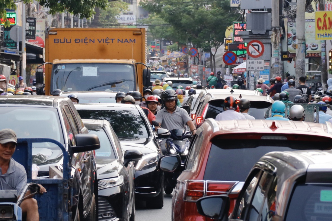 Xe máy luồn lách qua khe hở giữa hàng xe ô tô trên đường Phạm Văn Bạch (quận Tân Bình) - Ảnh: TIẾN QUỐC