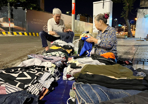 Vợ chồng ông Nguyễn Thành bày bán quần áo cũ từ lúc 4h sáng - Ảnh: YẾN TRINH