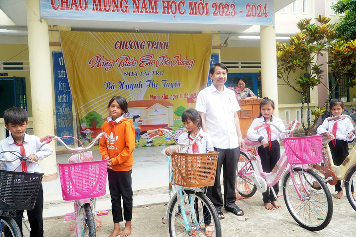Ông Lý Minh Tám trong một lần trao xe đạp cho học sinh ở xã Phước Kim - Ảnh: ĐOÀN CƯỜNG