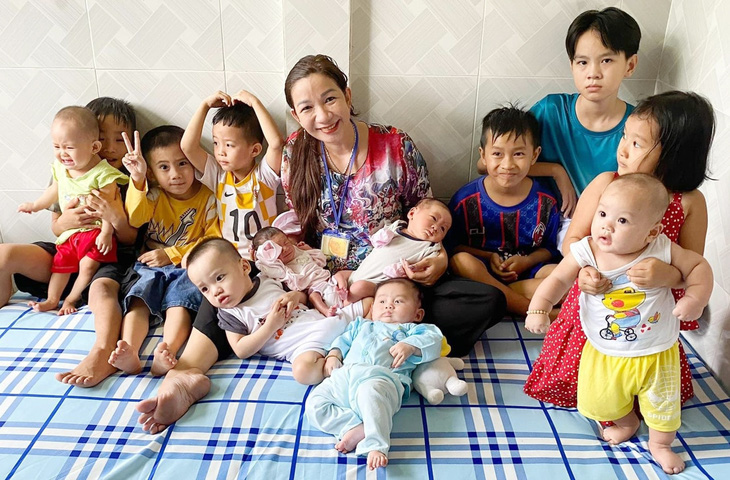 Chị Đặng Thị Ngọc Sương và các bé con của các mẹ bầu tại Mái nhà chung - Ảnh: NVCC