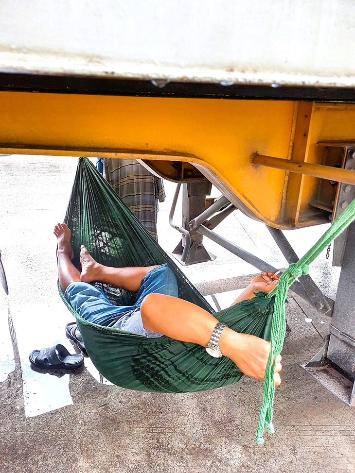 Tài xế mệt mỏi, mắc võng ngủ thiếp ngay dưới gầm xe ở biên giới Móng Cái - Ảnh TRƯƠNG NHẤT VƯƠNG