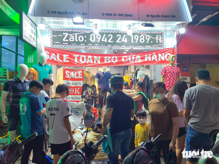 Một cửa hàng quần áo trên đường Nguyễn Trãi (quận 5) xả kho toàn bộ cửa hàng, khách mua vây kín sạp - Ảnh: NHẬT XUÂN