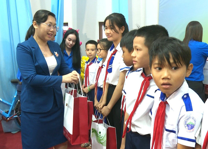 Bà Nguyễn Thị Hương - ủy viên Ban biên tập báo Tuổi Trẻ - trao quà Tết cho các học sinh nhận học bổng - Ảnh: NGUYỄN HOÀNG