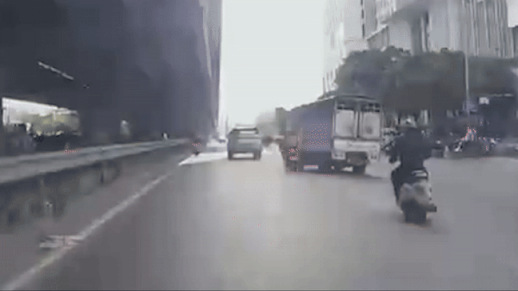 Cảnh chiếc xe tải chèn ngã hai người trên xe máy - Ảnh: D.A.