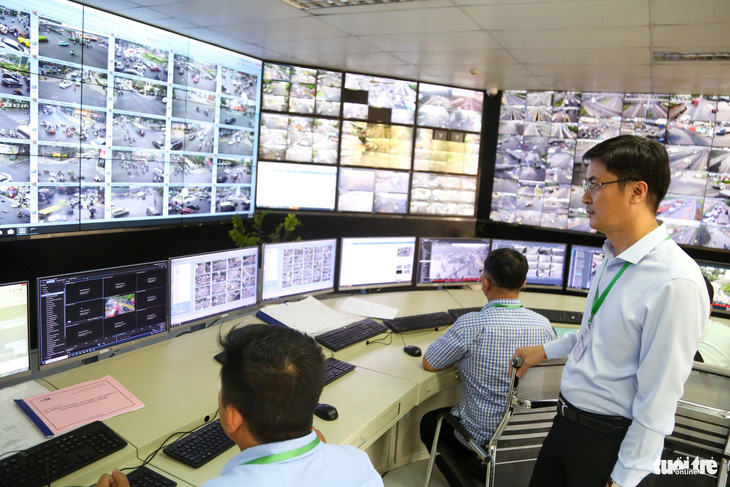 Ông Đoàn Văn Tấn - giám đốc Trung tâm quản lý điều hành giao thông thông minh - cùng các nhân viên theo dõi cụm camera giao thông tại khu vực sân bay Tân Sơn Nhất chiều 1-2 - Ảnh: PHƯƠNG QUYÊN