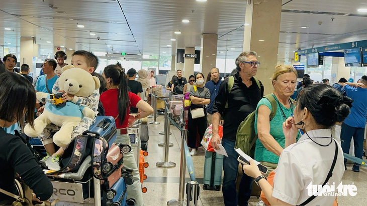Hành khách xếp hàng trật tự, chưa ghi nhận ùn tắc ở khâu check-in vào chiều 22 tháng chạp tại ga quốc nội sân bay Tân Sơn Nhất - Ảnh: CÔNG TRUNG