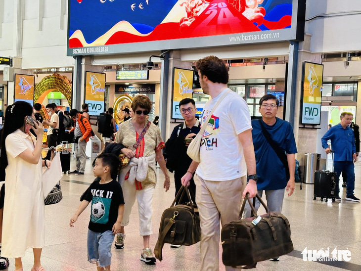Khách nước ngoài thong dong đi lại chiều 22 Tết tại sân bay Tân Sơn Nhất - Ảnh: CÔNG TRUNG
