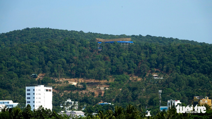 Từ cầu Nguyễn Trung Trực nhìn lên đỉnh núi Điện Tiên (phường Dương Đông, TP Phú Quốc), không khó bắt gặp một công trình đang xây dựng trên đó - Ảnh: CHÍ CÔNG