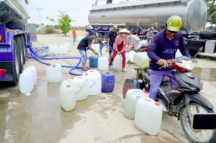 Người dân huyện Gò Công Đông (Tiền Giang) đến lấy nước tại các xe chở nước sạch miễn phí - Ảnh: MẬU TRƯỜNG
