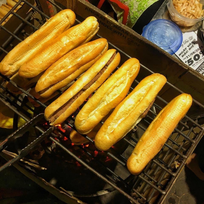 Bánh mì kẹp sẵn pate được nướng trên than trước khi rưới mỡ, thêm ruốc. Ảnh: Hoa Cỏ Dại