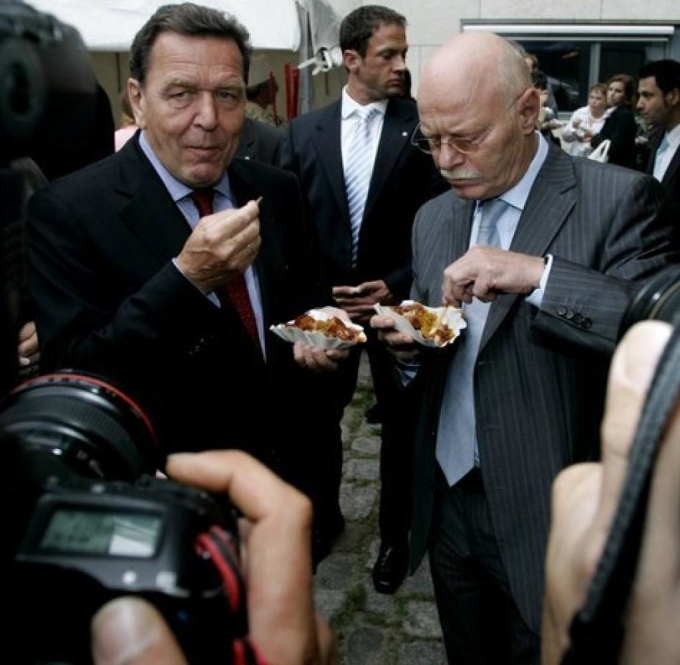 Cựu thủ tướng Gerhard Schroeder (trái) cũng được biết đến là một người hâm mộ lớn của món ăn này. Một sự thật thú vị về món ăn này nữa là theo truyền thống, mọi ứng viên cho chức thị trưởng Berlin đều được chụp ảnh tại một quầy bán currywurst. Ảnh: Welt