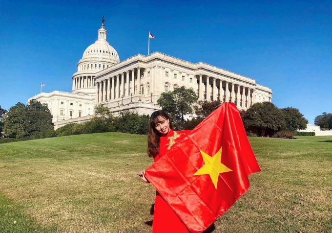 Vũ Anh Phương mặc áo dài truyền thống Việt Nam, cầm cờ tổ quốc chụp hình trước ... Mỹ. Ảnh nhân vật cung cấp
