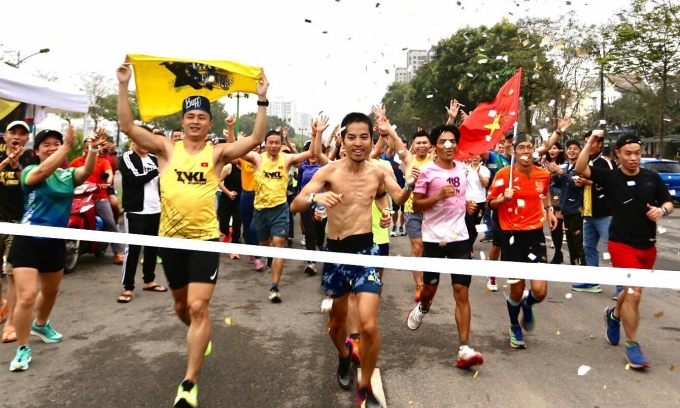 Đăng Hiếu (giữa) trong khoảnh khắc hoàn thành thử thách chạy 24h lúc 17h ngày 11/3, tại Việt Hưng, Long Biên, Hà Nội. Ảnh: CLB chạy VKL