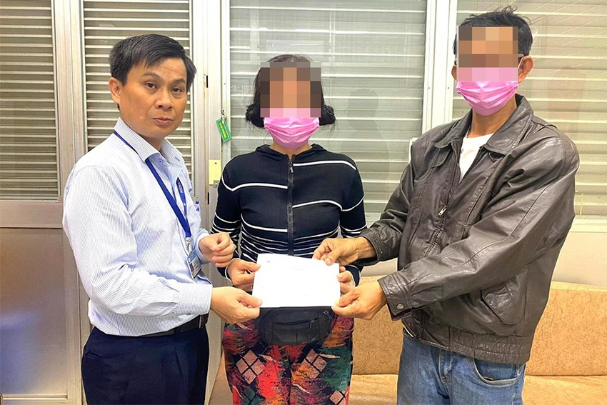 Lê Minh Hiển (trái) trao danh sách mạnh thường quân hỗ trợ viện phí cho vợ chồng ông M, một trong những bênh nhân nghèo chữa trị ở BV