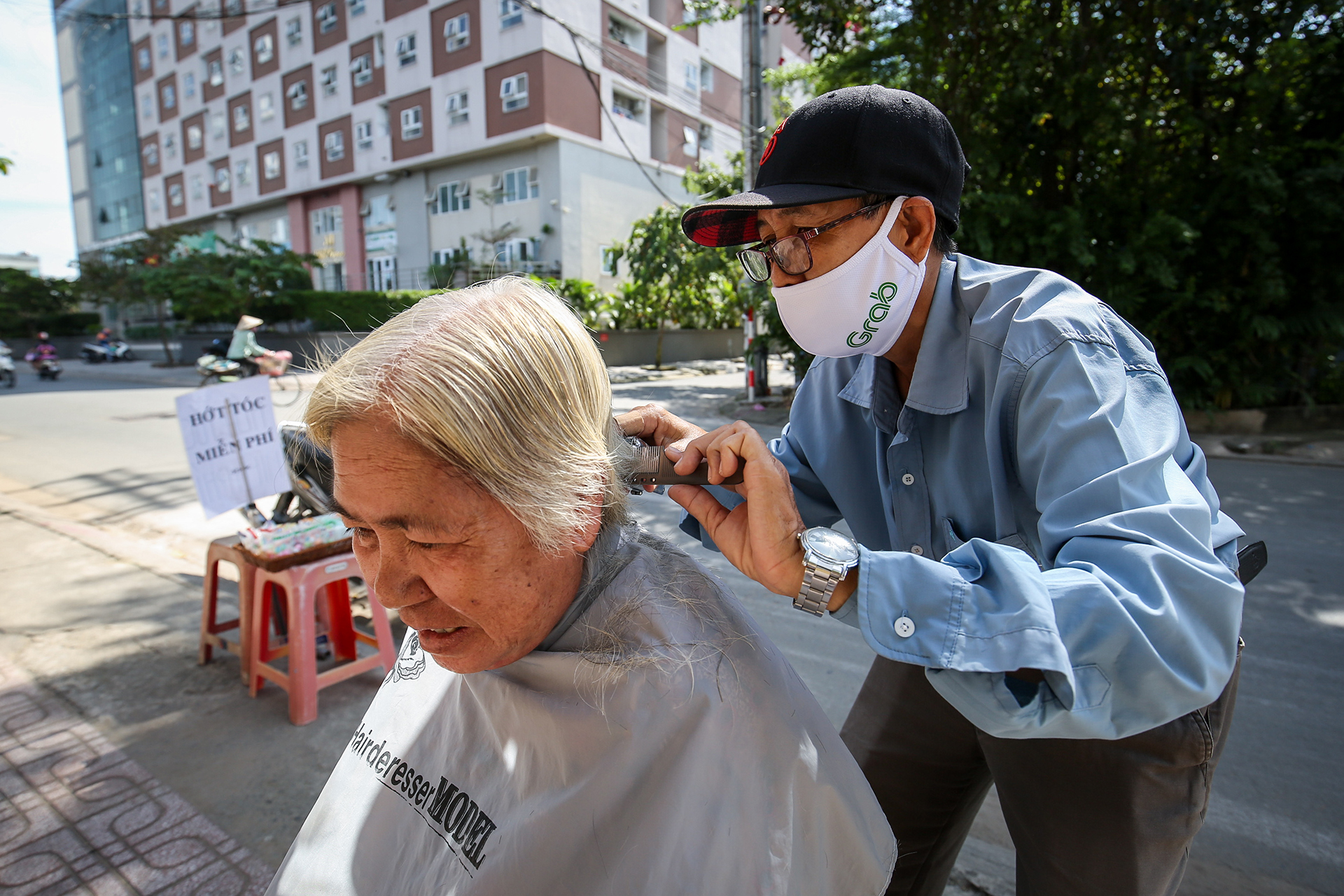 Một cụ bà lang thang bán vé số dọc tuyến đường Cây Keo (TP.Thủ Đức) được ông Phấn cắt tóc miễn phí. Ảnh: NHẬT THỊNH (Ảnh 1)