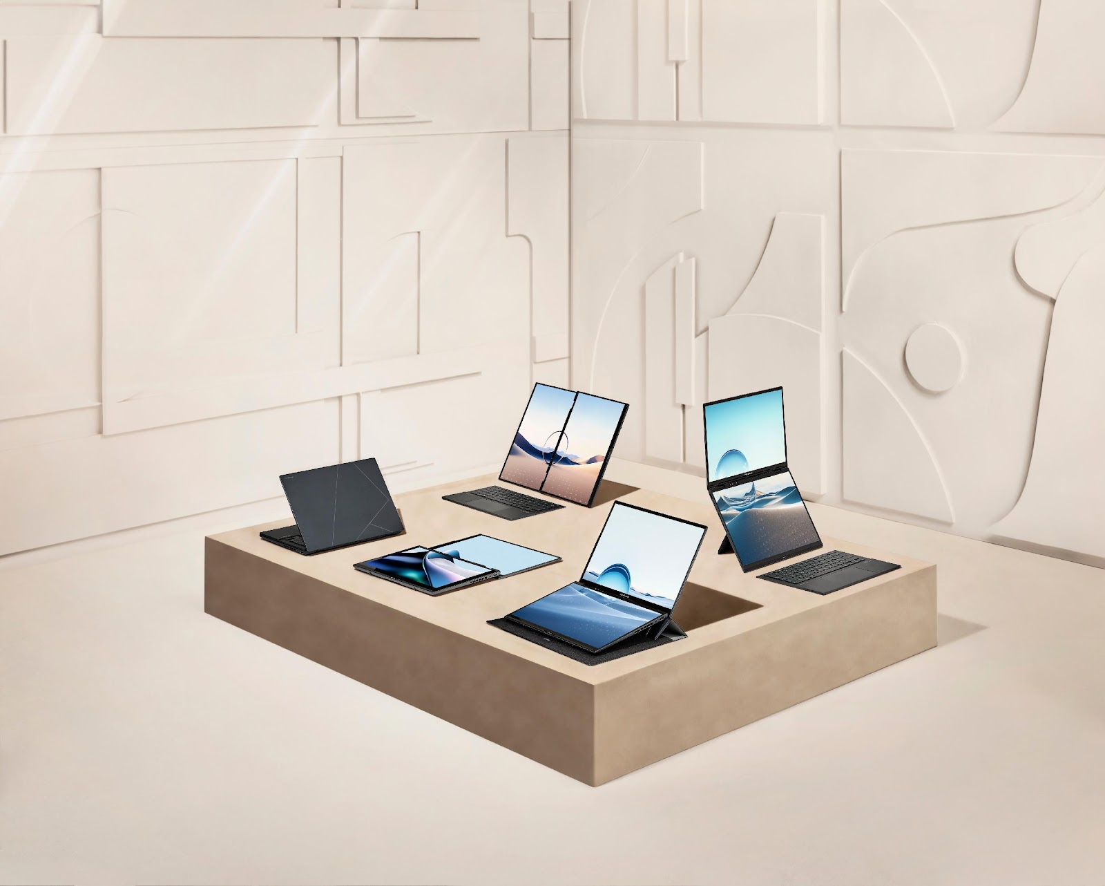 A group of laptops and tablets on a square tableDescription automatically generated
